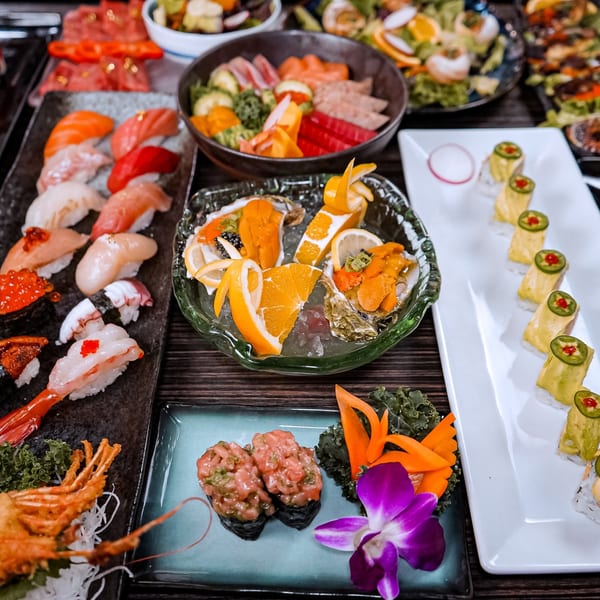 A vibrant spread of Sushiya's sushi, sashimi, oysters, and other Japanese delicacies on a dark wooden table.