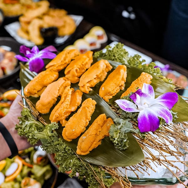 Sushiya's fresh uni (sea urchin) served on a banana leaf with purple orchids.