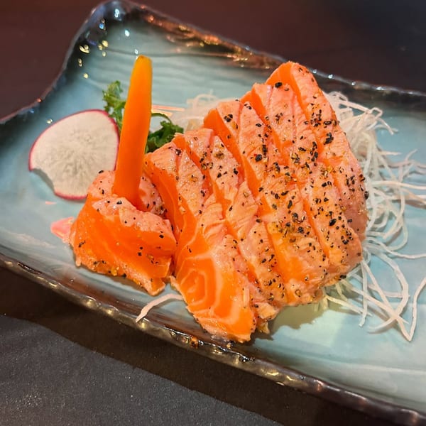 Sushiya's salmon sashimi, peppered and garnished with a carrot stick, radish, and shredded daikon.